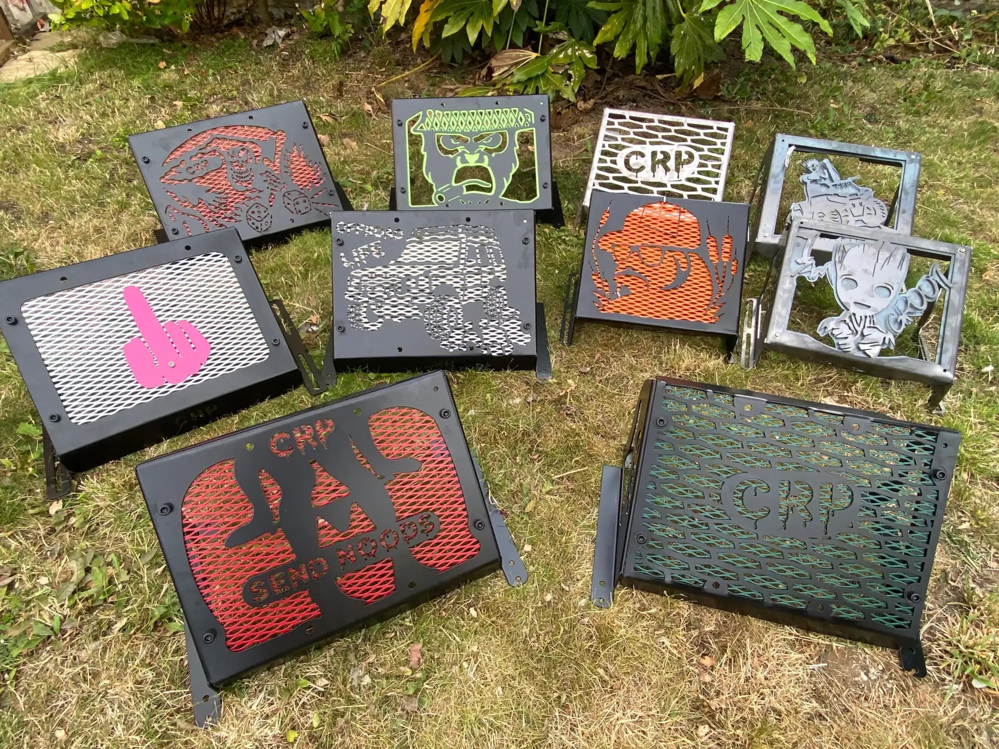 Black metal grill covers with colorful, laser-cut designs featuring characters and logos like groot, a pink finger gesture, and ’crp’ branding.
