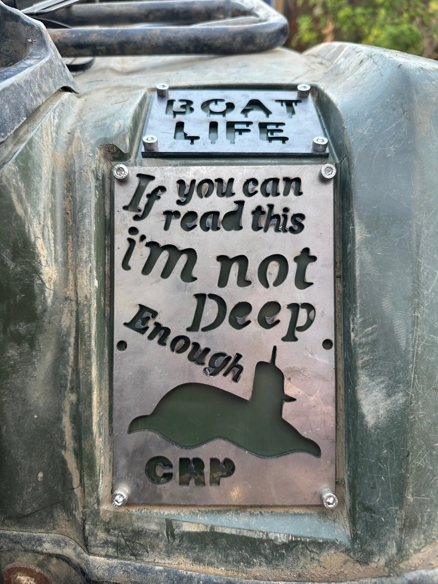 A metallic engraved safety plaque with submarine silhouette mounted on green vehicle for honda custom fender plates