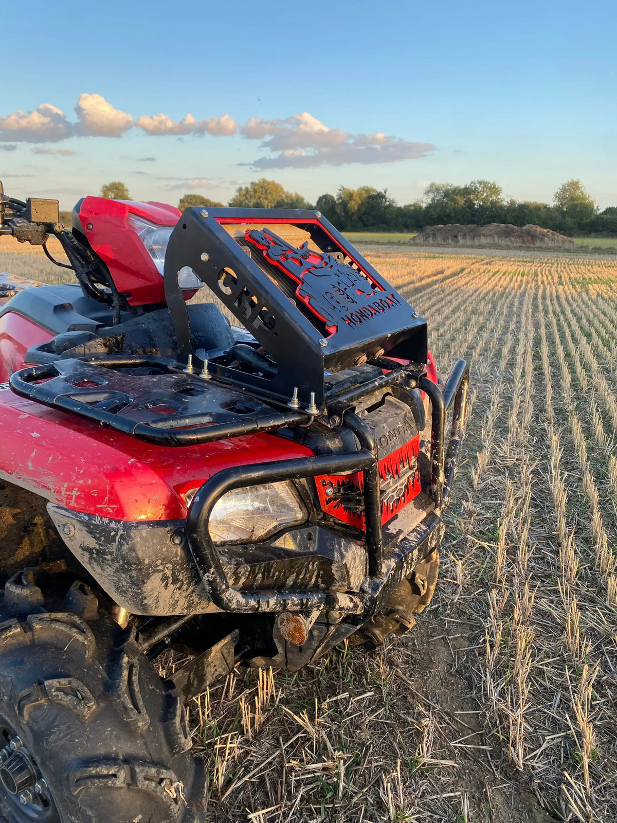 Black metal rear rack with red laser-cut honda logo mounted on red atv for honda foreman radiator relocation kit