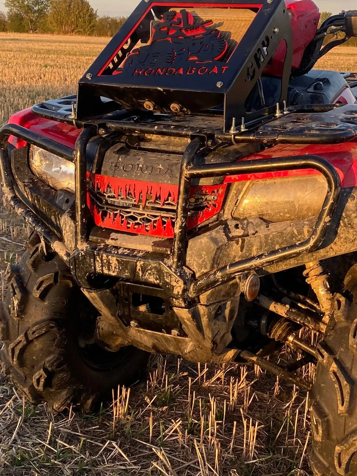Red and black honda trx 420 2014 500 14-19 atv with rugged mud-splattered heavy-duty protective grille cover