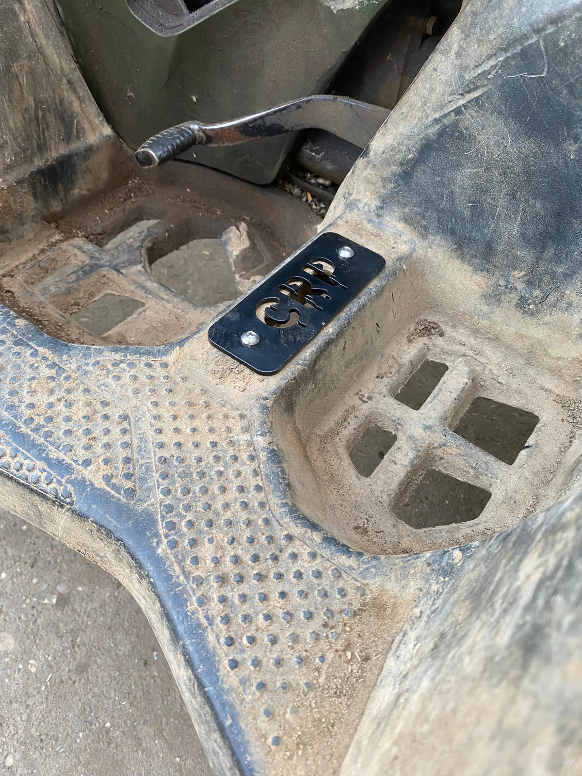 Black metal crp engraved plate on muddy footrest of honda trx 420 500 520 heavy-duty flat footpegs