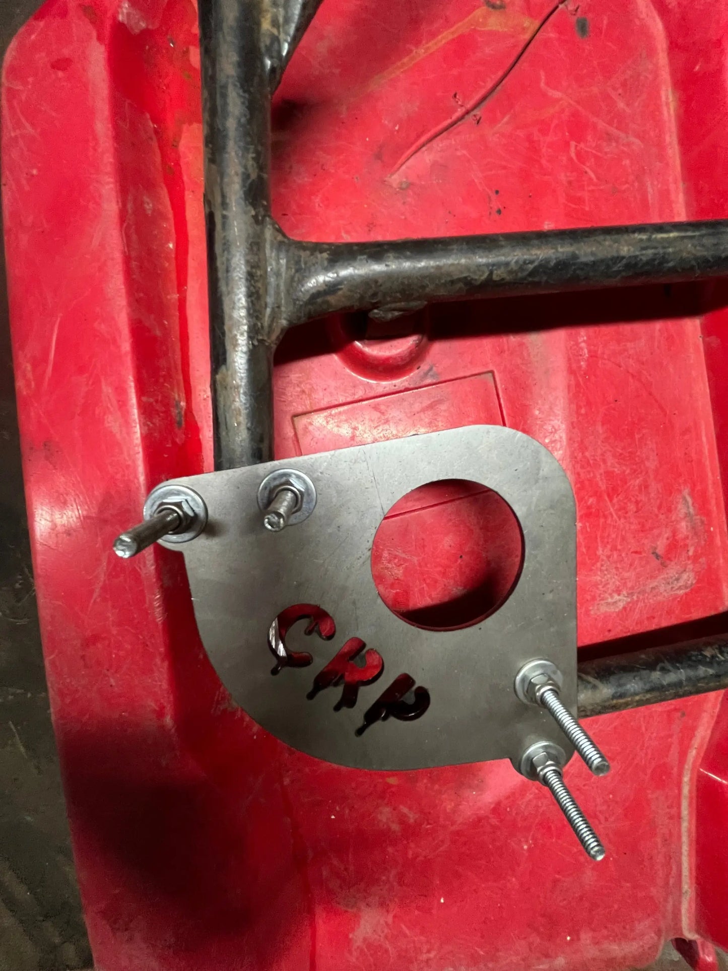 Silver metal heavy-duty snorkel bracket with circular cutout and red crp engraving secured by four bolts on black frame