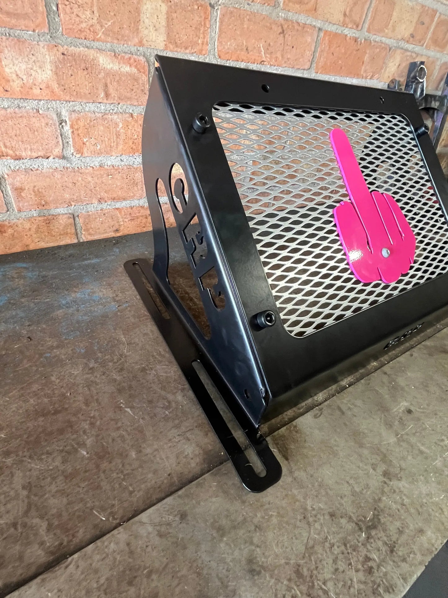 Black metal mesh speaker enclosure with bright pink finger gesture cutout for Kawasaki Brute Force 750 radiator kit