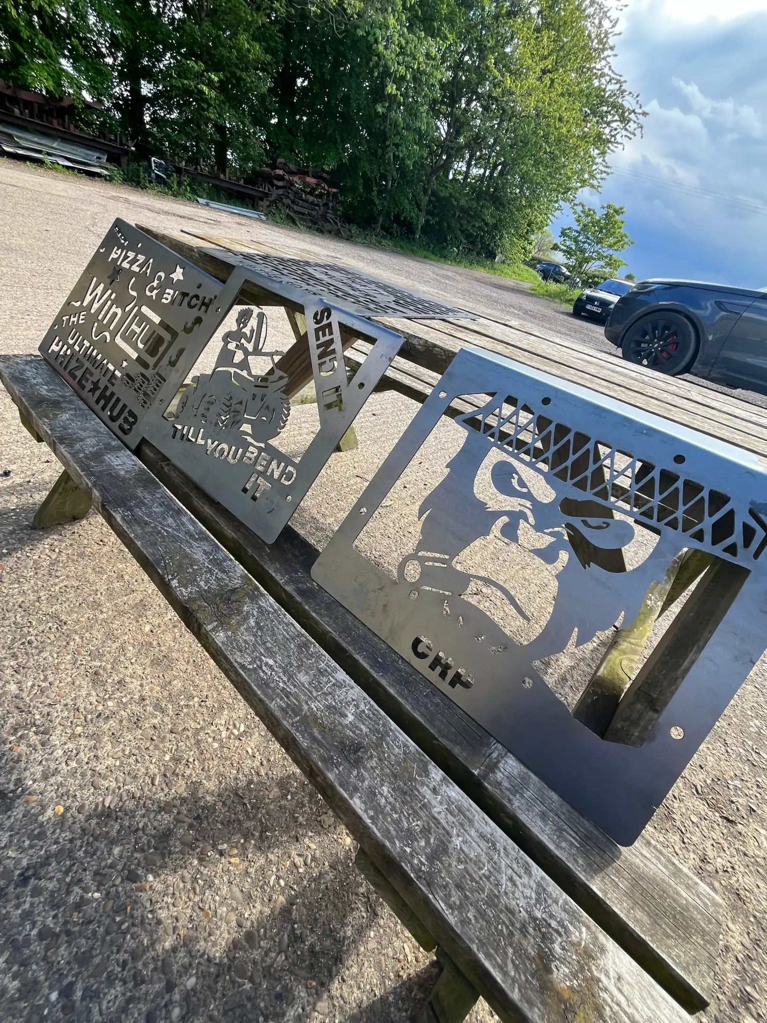 Metallic gray, laser-cut steel signs with bold black text and a gorilla silhouette design.