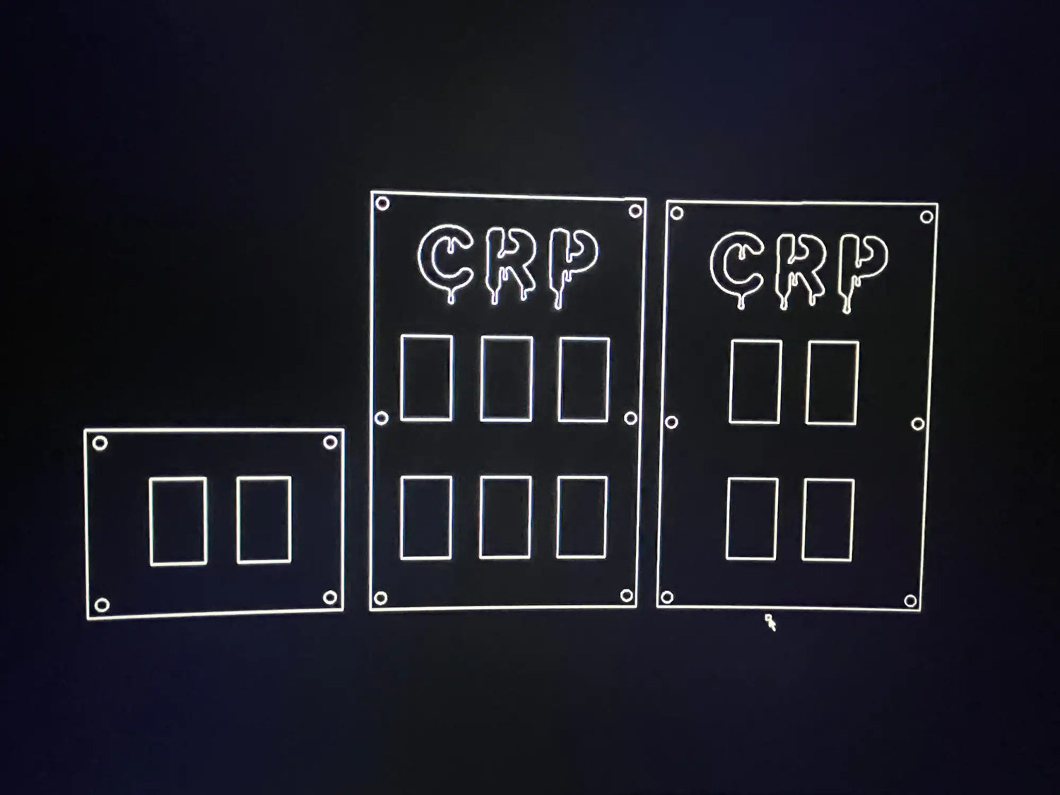 Three white-outlined electrical switch plates with ’crp’ lettering at the top, displayed against a dark background.
