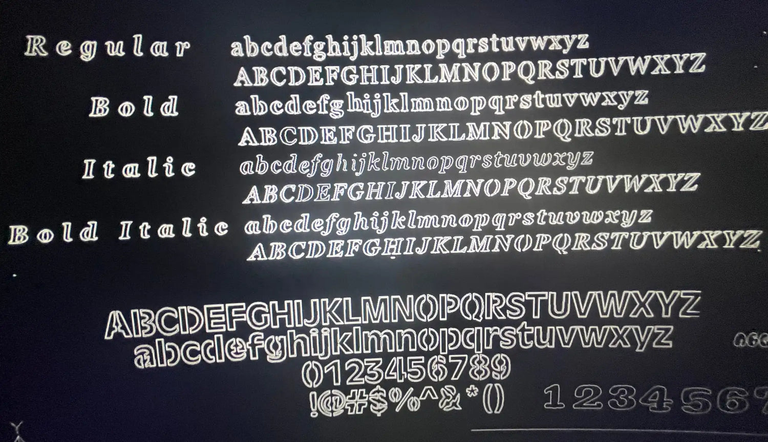 White chalk-style font samples displayed on a dark background, showcasing regular, bold, italic, and bold italic styles with lowercase letters, uppercase letters, numbers, and symbols.