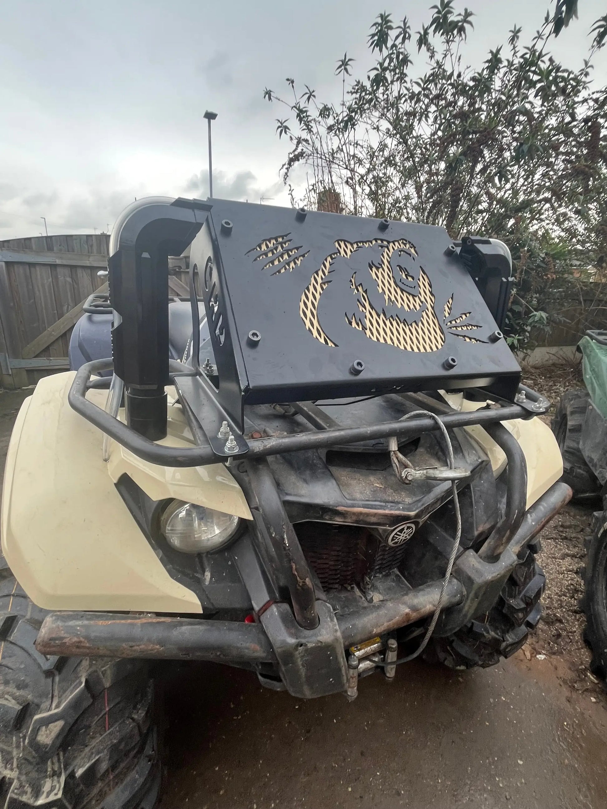 Black metal front guard with gold panda face cutout mounted on yamaha grizzly 550 700 off-road vehicle radiator kit