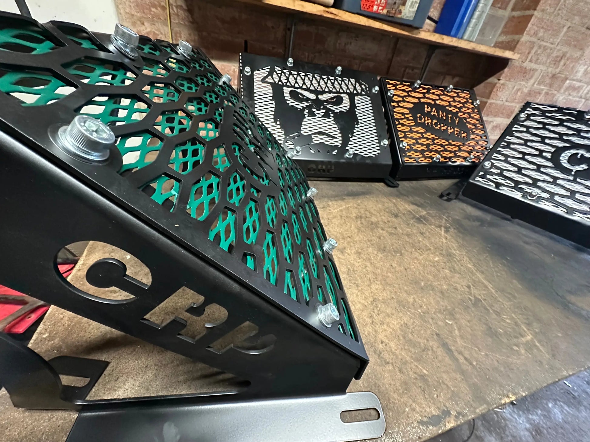 Black metal motorcycle engine cover with green honeycomb mesh and silver bolts for Yamaha Grizzly radiator kit