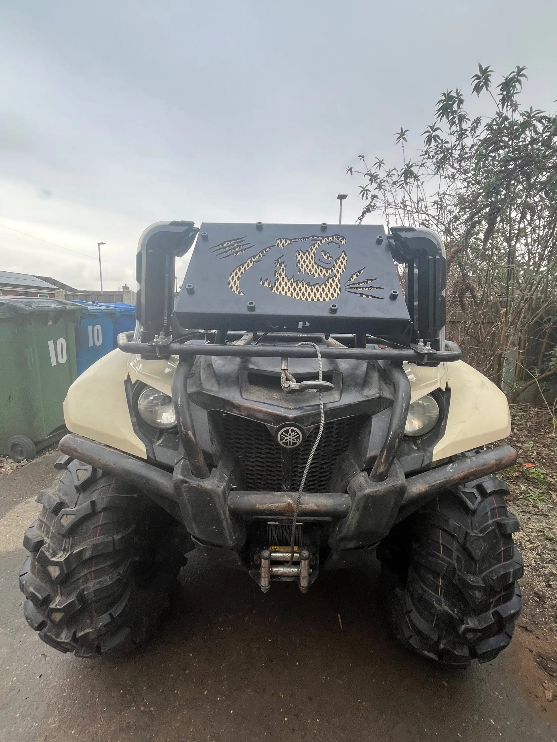 Black metal front rack with gold panda design mounted on Yamaha Grizzly Kodiak 700 radiator relocation kit