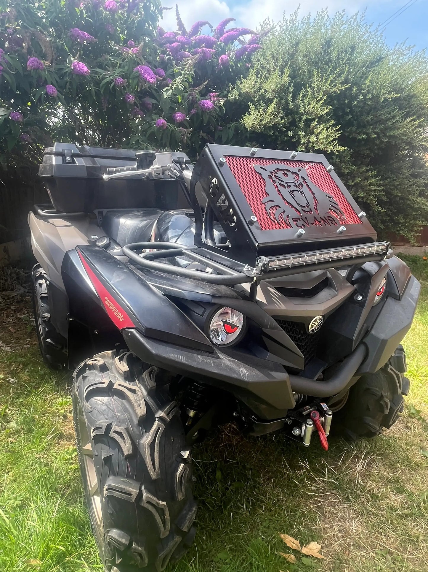 Black and red can-am outlander atv with rugged tires and front grille shown with yamaha grizzly kodiak 700 radiator relocation kit