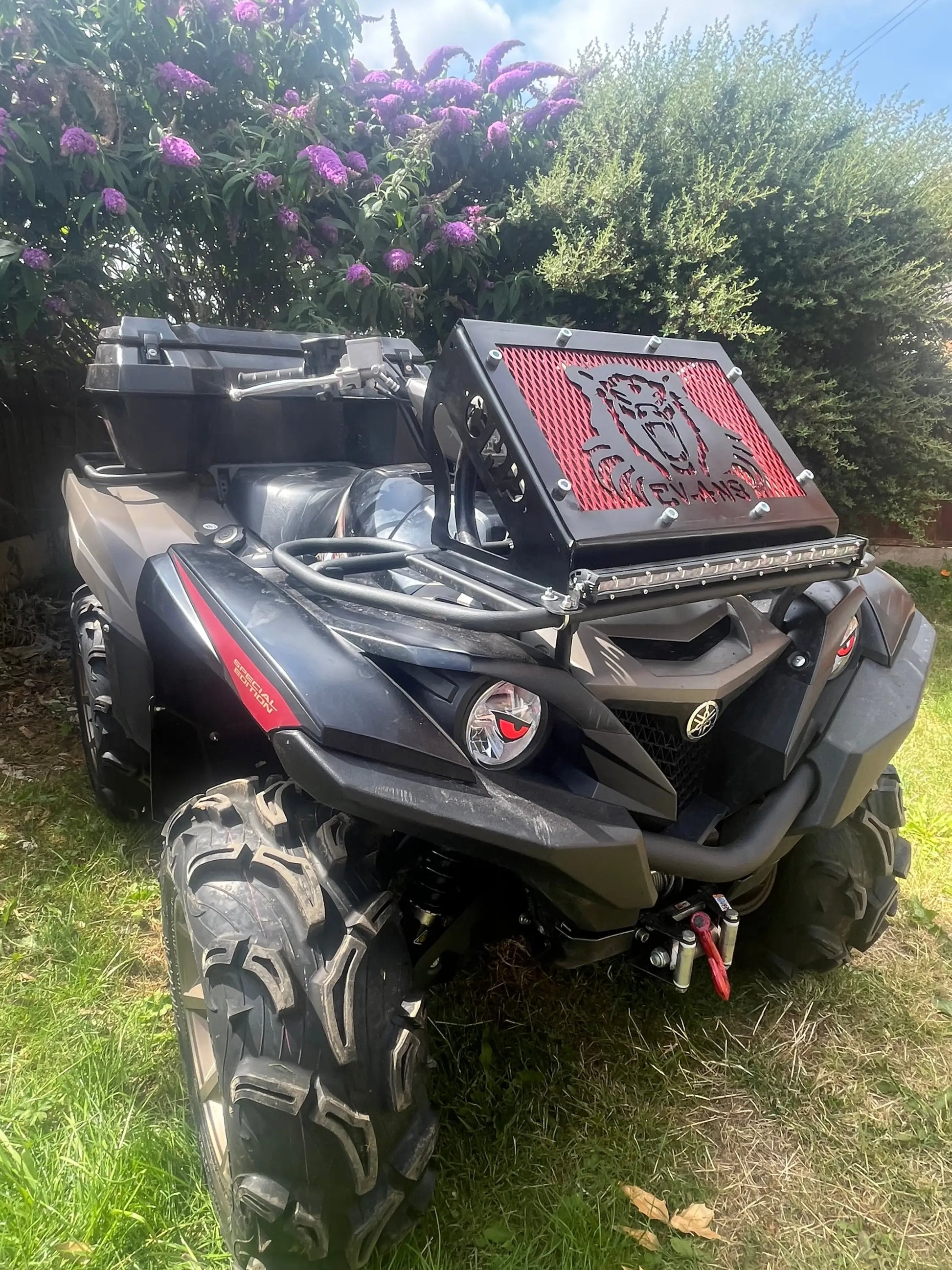 Black and red can-am outlander atv with rugged tires and front grille shown with yamaha grizzly kodiak 700 radiator relocation kit