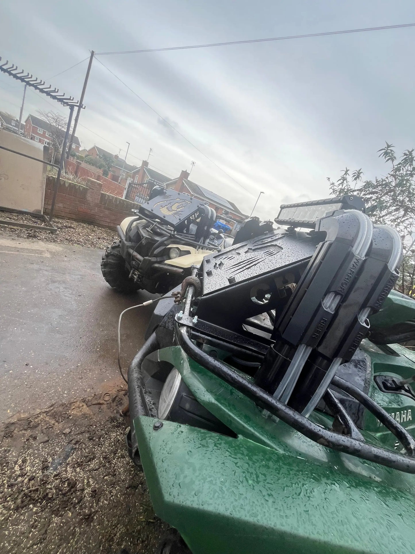 Green yamaha grizzly kodiak 700 off-road vehicle with black and silver radiator relocation kit components visible