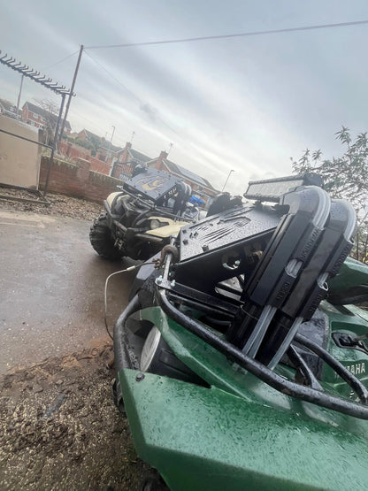 Green yamaha grizzly kodiak 700 off-road vehicle with black and silver radiator relocation kit components visible